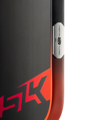 Brushed-metal device corner with red HK logo and vertical badge reading INERTIA 5G TUNED