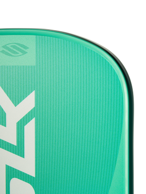 Teal-green board corner with vertical white 'ZY' logo and textured deck pad along a rounded rail.